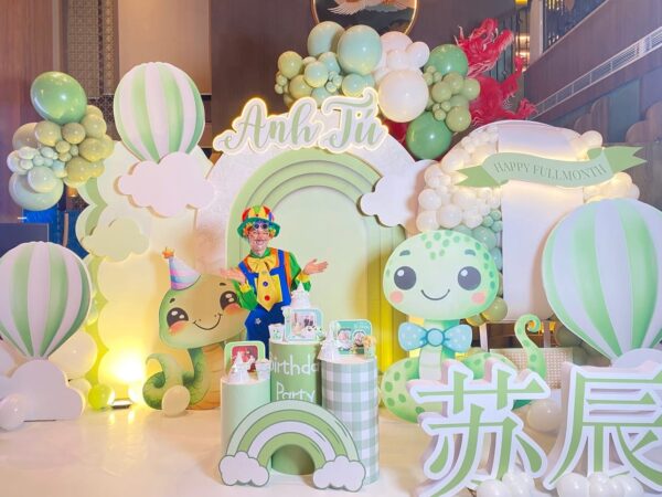 Backdrop trang trí đầy tháng bé tuổi Tỵ kết hợp chú hề hoạt náo khuấy động không khí buổi tiệc