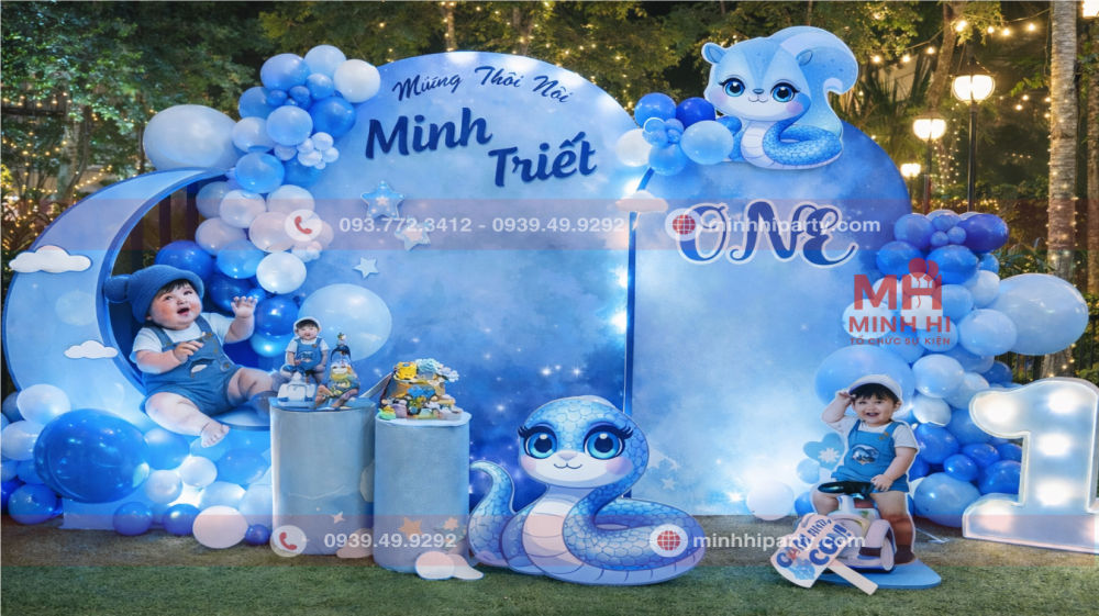 Trang trí backdrop tiệc thôi nôi bé trai tuổi Rắn hiện địa tone xanh với không gian ngoài trời