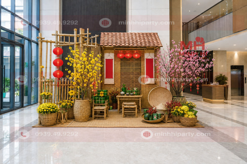 Trang trí tiểu cảnh Tết 2027 cho chung cư tại sảnh với nhà tre, hoa mai, hoa đào, đèn lồng và bánh chưng.