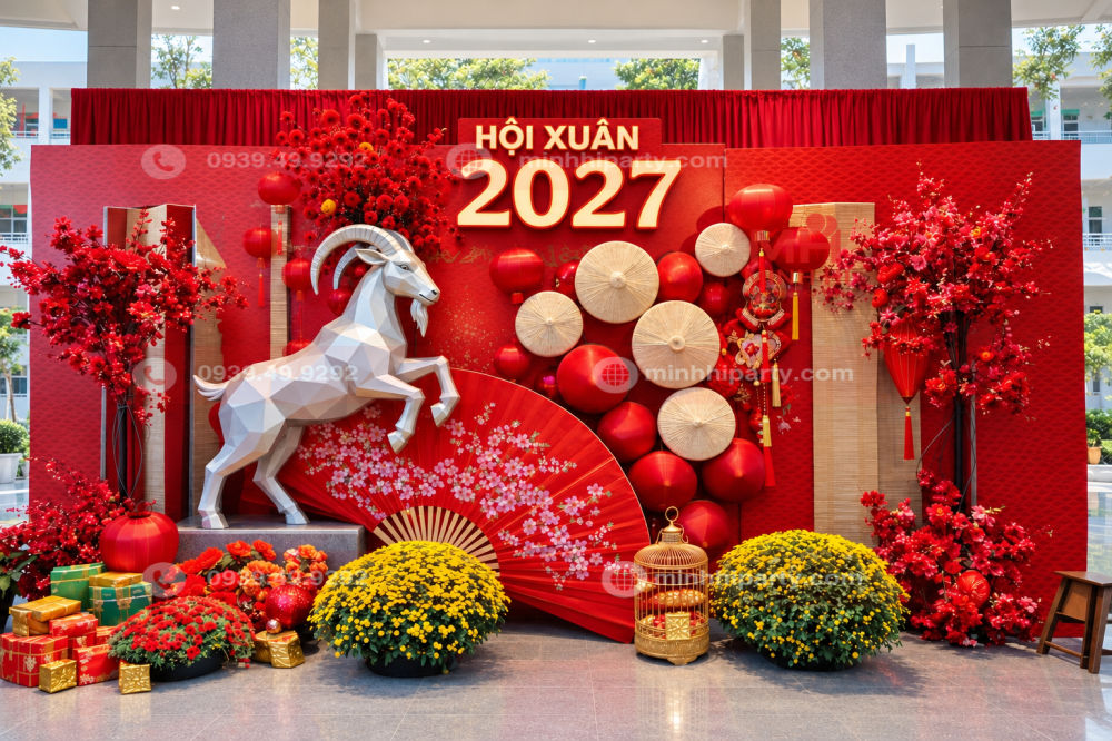 Mẫu trang trí Hội Xuân 2027 với dê 3D bên trái, cụm nón lá và đèn lồng bên phải