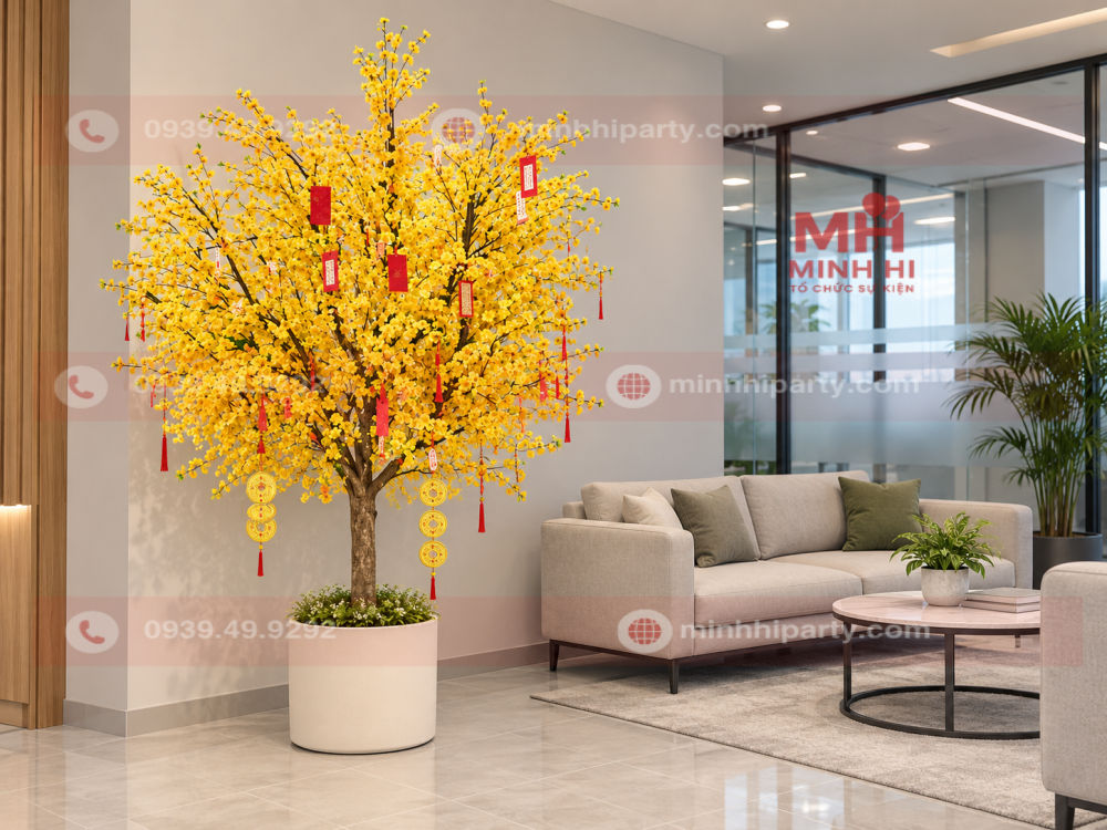 Cây mai giả decor tết 2027 cho văn phòng tán gọn, treo bao lì xì đỏ và dây đồng xu, đặt trong chậu trắng cạnh sofa tiếp khách.
