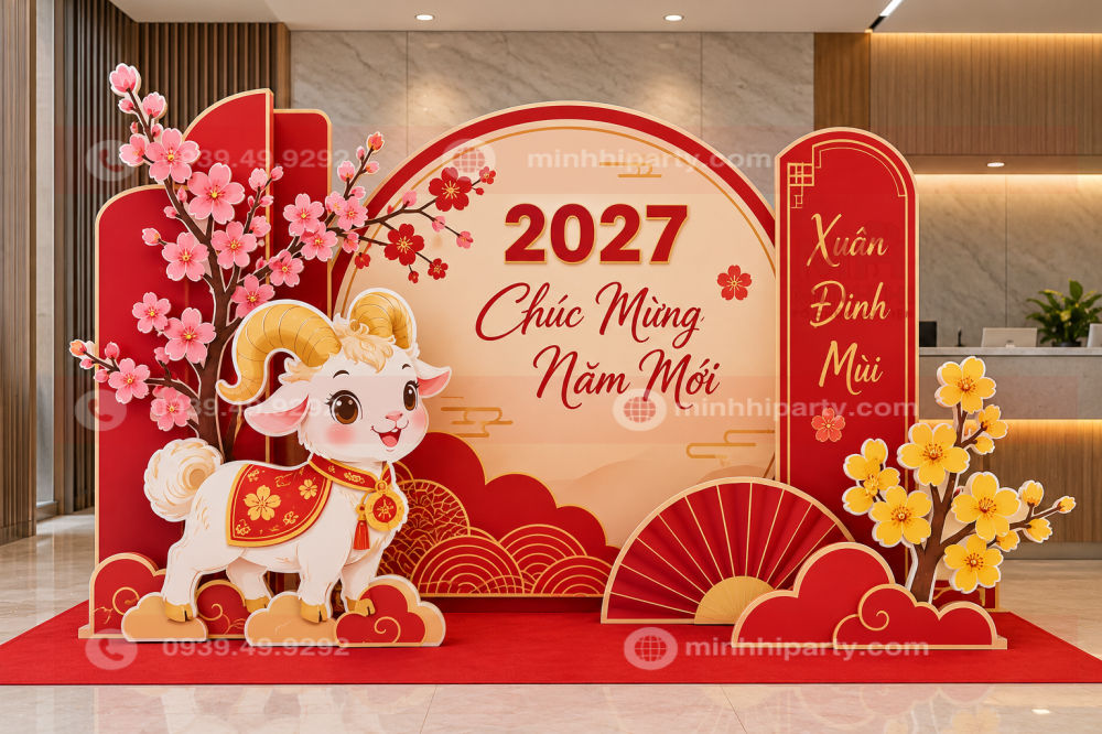trang tri quay le tan voi mo hinh de tet 2027 Trang trí mô hình dê Tết 2027 với tiểu cảnh formex cắt CNC ghép lớp, backdrop đỏ kem, hoa đào và hoa mai tại sảnh văn phòng.