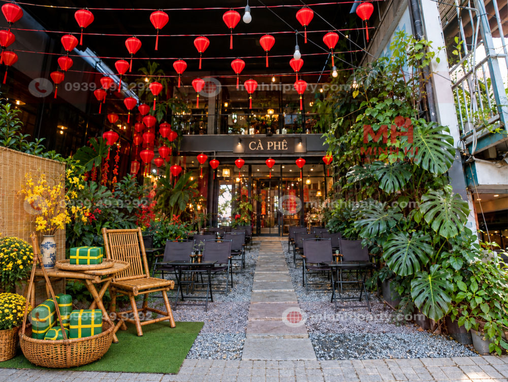 Mô hình bánh chưng, bánh tét màu xanh buộc dây vàng trong tiểu cảnh Tết đơn giản tại quán cafe.